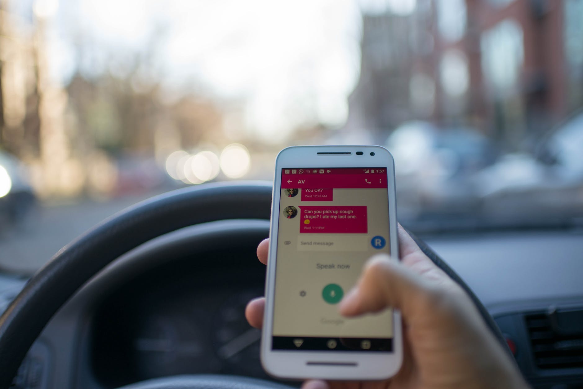 driver holding cell phone at the wheel