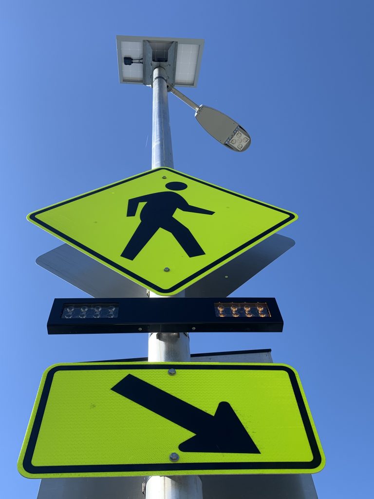 low shot of full rectangular rapid flashing beacon system with overhead street lighting fixture