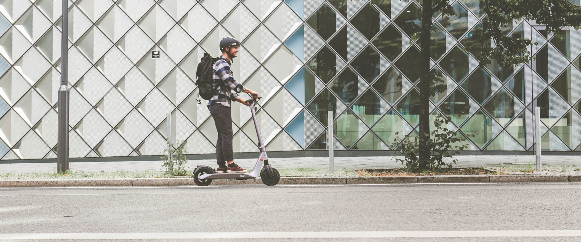 young boy riding scooter on sidewalk