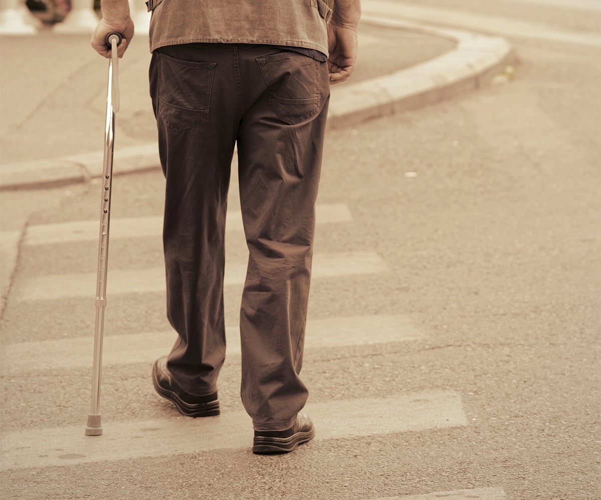 man with cane crossing street